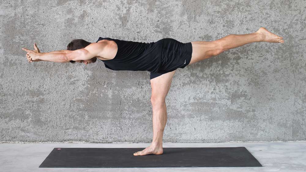 A Warrior 3 pose, demonstrated for people starting begginner yoga for men