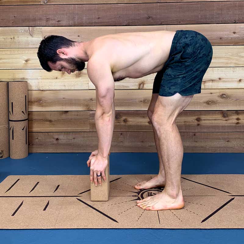 Modified forward fold demonstrated for people starting beginner yoga for men