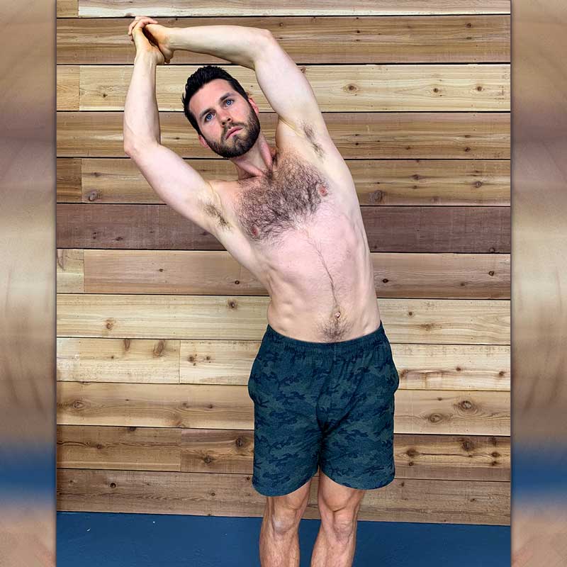 Modified standing side bend demonstrated for people starting beginner yoga for men