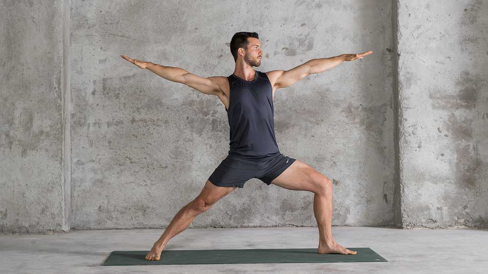 Warrior 2 pose, demonstrated for people starting beginner yoga for men