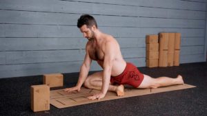 Male Yoga Instructor demonstrated pigeon pose on mat
