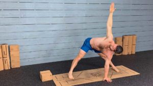 Male Yoga Instructor Shows Wide Legged Forward Fold with Twist Pose