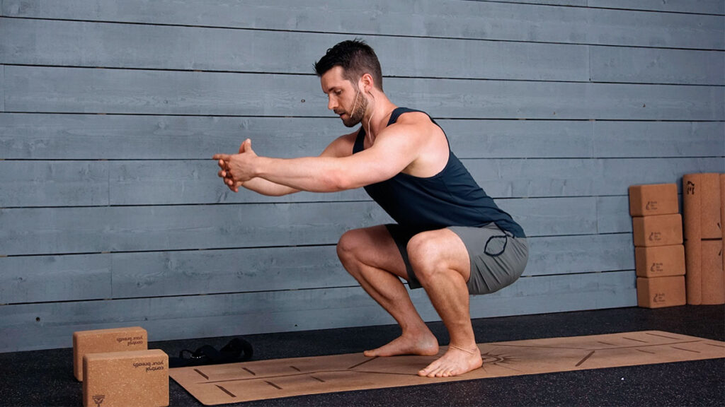 male yoga instructor demonstrated deep squat pose for morning yoga routine