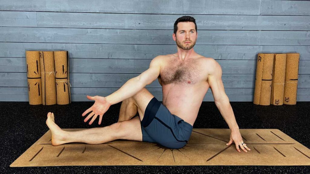Shirtless Male Yoga Instructor Demonstrating Seated Twist Yoga Pose For Better Mindfulness and Breathing