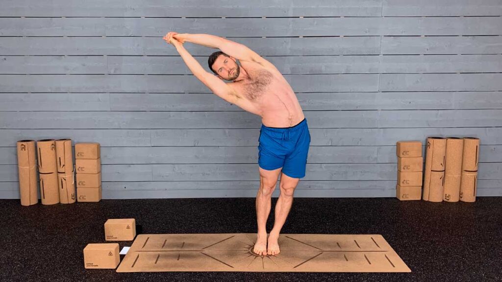 Shirtless Male Yoga Instructor Demonstrating Standing Side Bend Yoga Pose for Mindfulness