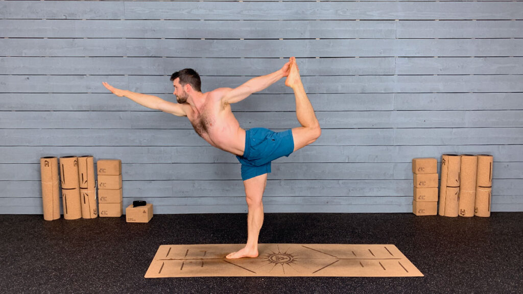 Shirtless male yoga instructor demonstrates standing bow pose