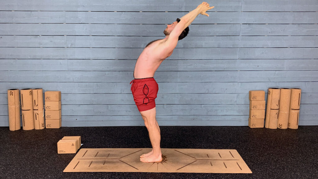 shirtless male yoga instructor demonstrates standing back bend pose