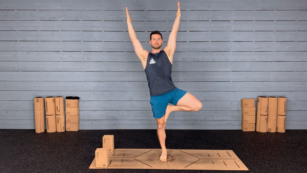 male yoga instructor demonstrates tree pose
