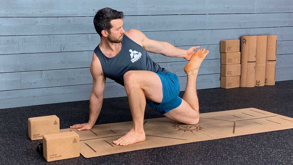Male yoga instructor demonstrates lizard pose with reaching back as one of many yoga poses for tight hips