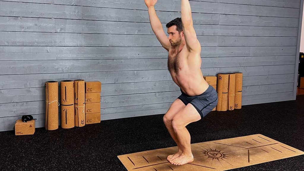 Shirtless male yoga instructor demonstrates chair yoga pose